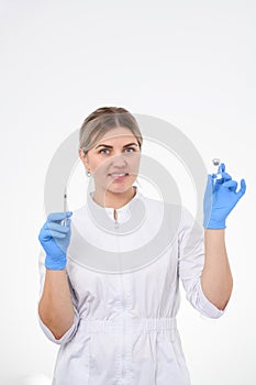 Dermatologist in white clothes and gloves standing with a syringe in hand