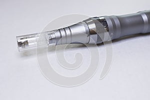 Dermis stamp electric pen. Dermapen. Needle mesotherapy treatment. photo