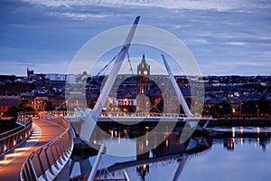 Derry, Ireland. Illuminated Peace bridge in Derry Londonderry, City of Culture, in Northern Ireland with city center at