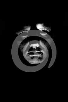 Desaturated man`s face illuminated from below with flashlight photo