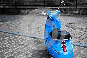 Desatured picture of blue classic scooter or vespa Peugeot Django parked in the street photo