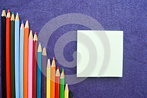 A descending chart of colorful, bright, variegated drawing pencils, a notebook