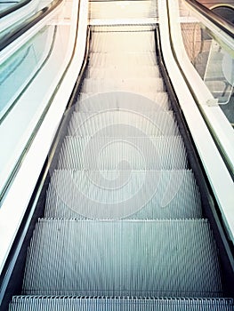 Descending escalator moving stairs in city shopping mall or business office building. Abstract concept of direction destination mo
