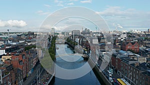 Descending footage of Liffey river and its waterfronts. Pedestrians at Hapenny footbridge. Dublin, Ireland