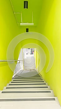 A descending staircase with bright lime-colored, colorful hues, lime green background indoor corridor