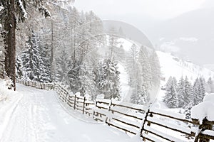 Descending winding country road with the scenic view in the mountains during snowfall   near Sterzing/ Vipiteno South Tyrol, Dol