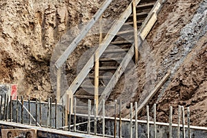 Descent into a deep pit during the construction of the building. Safety in construction. Ladder for descending to reinforced