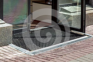 Descent on entrance to store from pedestrian sidewalk with rubber foot mat.