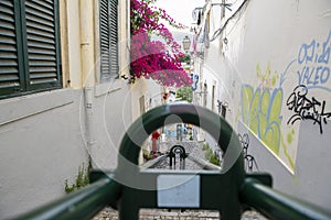 Descent of stone stairs between houses with central green metal railing