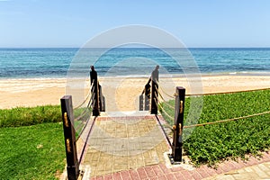 Descent to sea on sandy beach on wooden staircase