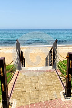 Descent to sea on sandy beach on a wooden staircase