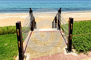 Descent to sea on sandy beach on wooden staircase