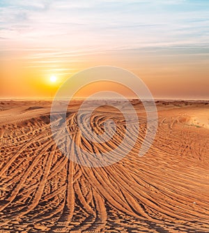 Desert covered with tire-treads in the sunset
