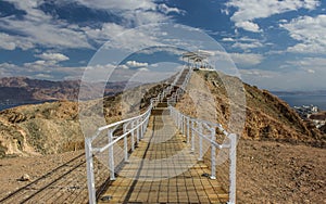 Desert dramatic scenery environment space sand stone rocky hill top with fenced path way to gazebo view point place