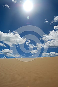 Desert dune and white clouds
