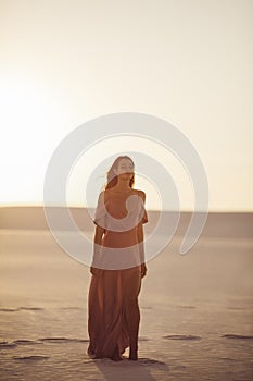 Desert Fashionable Woman Model in Evening Pink Dress at Sunset