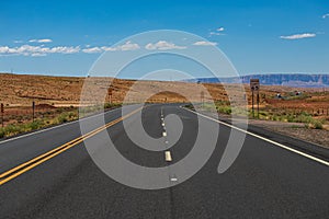 Desert highway at sunset, travel concept, USA. Asphalt highway road and sky sunset clouds landscape. American roadtrip.