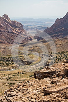 A desert highway winds through steep rock walls.
