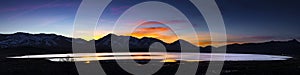 Desert lake, flooded playa at Sunset with mountain ranges and colorful clouds. photo