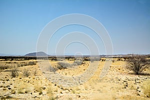 Desert landscape with a distant hill in the distance and dry sand in the foreground