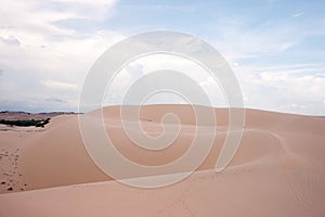 Desert landscape dunes in the afternoon with blue skies white clouds.