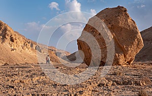 Desert landscape with a huge boulder on a hiking trail.