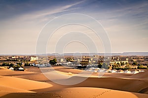 Desert landscape with Moroccan palace. Arabian nights hotel. Sand dunes of Erg Chebbi