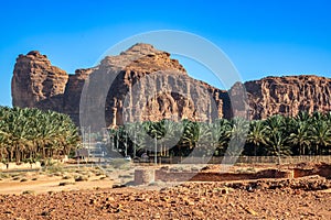 Desert mountains with ruins of Dadan and road with palms, Al Ula, Madain Salih, Saudi Arabia photo
