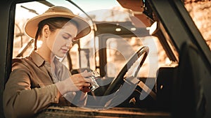 Desert Road Trip: Portrait of Professional Female Travel Photographer Using Camera, Taking Photos