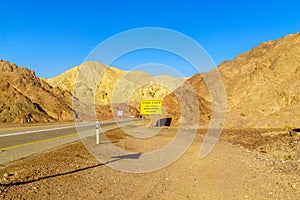 Desert road, with a warning sign
