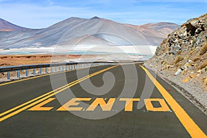 Desert Road with the Word LENTO Means SLOW in Spanish Along Salar de Talar Salt Lakes in Los Flamencos National Reserve, Chile photo