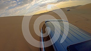 Desert safari off road, cockpit view from cabin or car, view to sunset. Jeep or SUV or 4x4 vehicle rides on desert dune