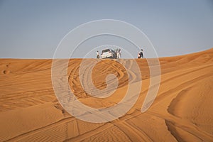 Desert safari tour in UAE. Four wheel drive desert safari car on a san dune with a tourists