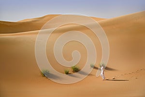 Desert, sand dunes, white dressed woman walks