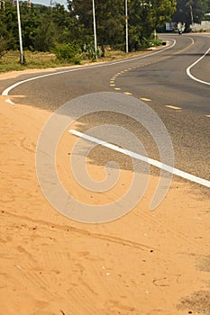 Desert sand steps on an asphalt road.