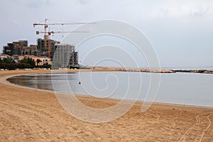 Desert sandy beach and new buildings. Limassol, Cyprus