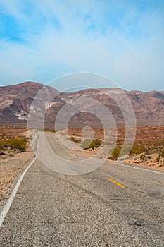 Desert scenic road in Death Valley with mountain backdrop, California, USA. Amazing natural panorama