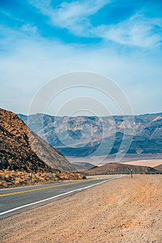 Desert scenic road in Death Valley with mountain backdrop, California, USA. Amazing natural panorama
