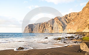Desert solitary beach in Tenerife with Los Gigantes cliffs