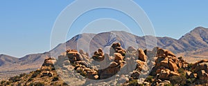Desert Terrain Mountain Rocks against a bright Blue Cloudless Sky photo