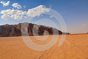desert valley with orange sand and rocky mountains