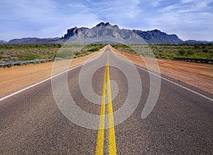 Desert wilderness road leading to mountain.