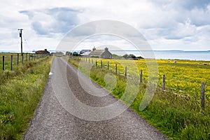 Deserted back road to a costal village and cloudy sky