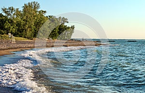 Deserted beach with lifeguard chairs and trees in background on Presque Isle on Lake Erie