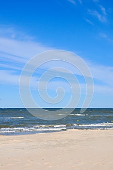 Deserted beach in Palanga Lithuania. Yellow sand on beach near blue sea. Recreation, sea travel, cruise and relax concept