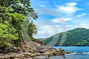 Deserted beach surrounded by forests and mountains in Trindade