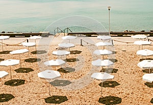 Deserted beach with white umbrellas