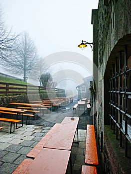 Deserted beer table sets at a monastery by a foggy and wet weather