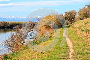 Deserted hiking path with snowy mountains peaks in background