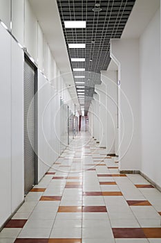 Deserted mall corridor with closed retail space, vertical frame